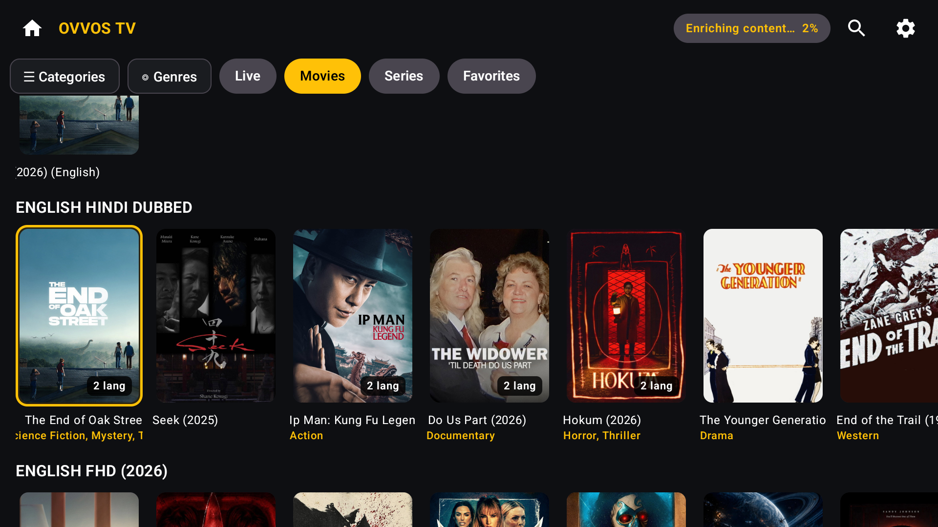 Movie poster rows on Android TV: one card per title with 2 lang badges, genre lines under each poster and the gold focus ring on the first card